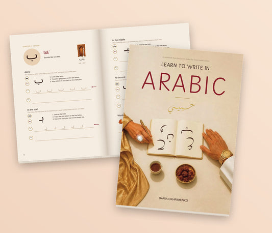 The Learn to Write in Arabic cover on top of the open workbook